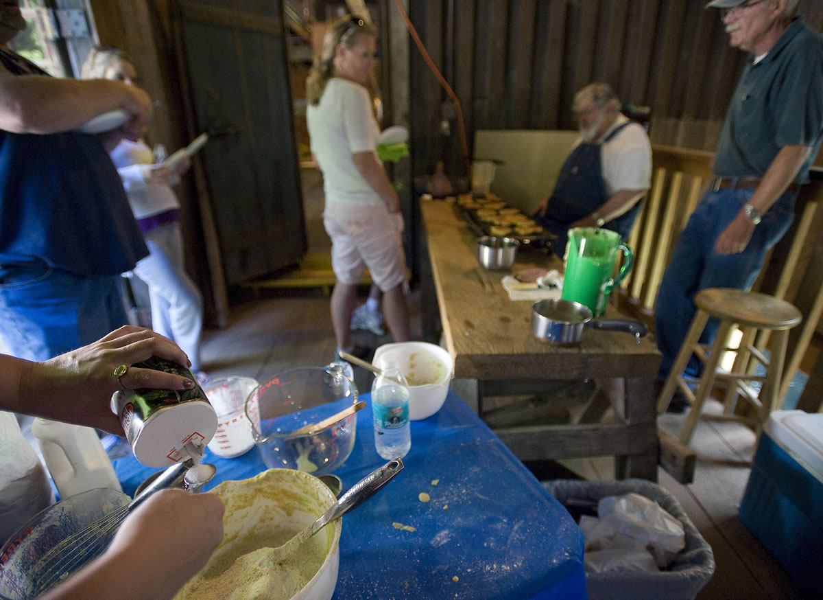 Volunteer Chelsea Gaya, left, 26, of La Center adds salt to blueberry pancake batter at the 2011 sampling event at the Cedar Creek Grist Mill in Woodland.