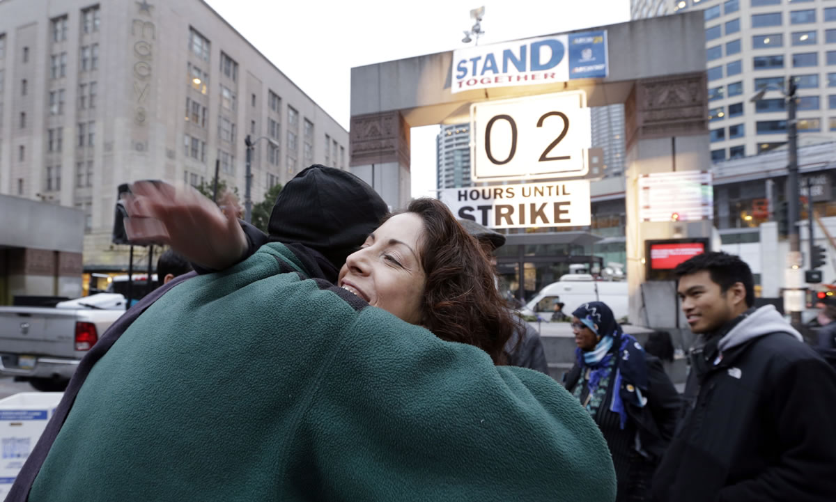 Union employee Elena Perez, right, embraces colleague Steve Williamson near a &quot;countdown clock&quot; for a strike deadline after a tentative agreement was announced Monday in Seattle.
