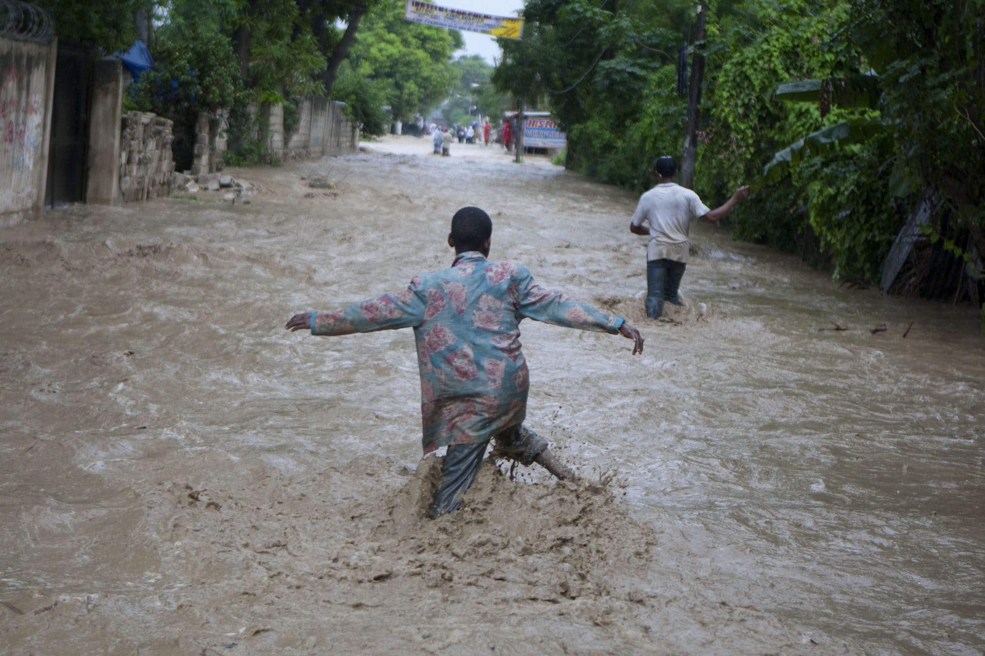 Residents wade through a flooded street caused by heavy rains from Hurricane Sandy in Port-au-Prince, Haiti, Thursday, Oct. 25, 2012. Hurricane Sandy rumbled across mountainous eastern Cuba and headed toward the Bahamas on Thursday as a Category 2 storm, bringing heavy rains and blistering winds.