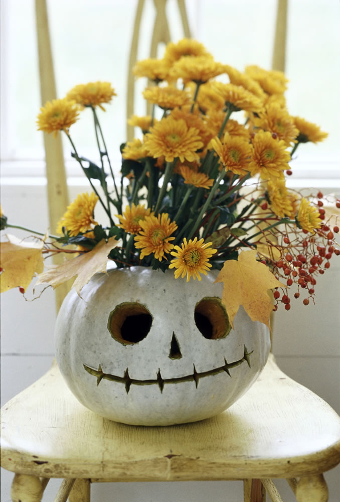 A floral arrangement in a pumpkin that is carved into a likeness of the animated character Jack Skellington from &quot;The Nightmare Before Christmas.&quot;