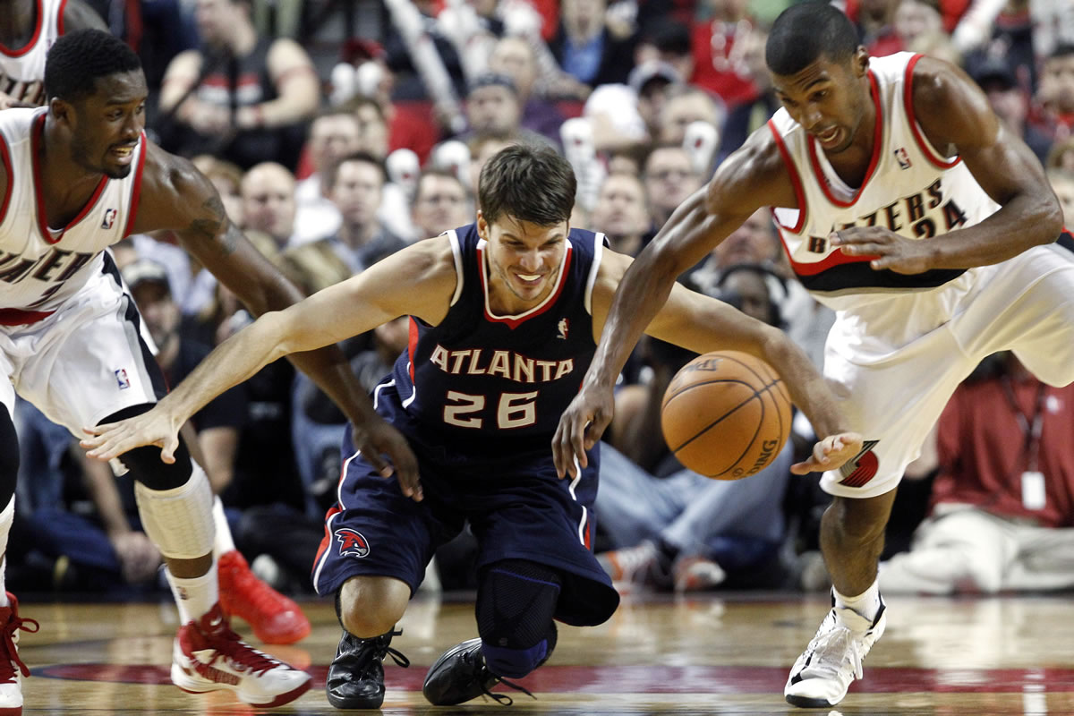 Atlanta Hawks guard Kyle Korver (26) chases down a loose ball with Portland Trail Blazers' Wesley Matthews, left, and Ronnie Price during the second half Monday.