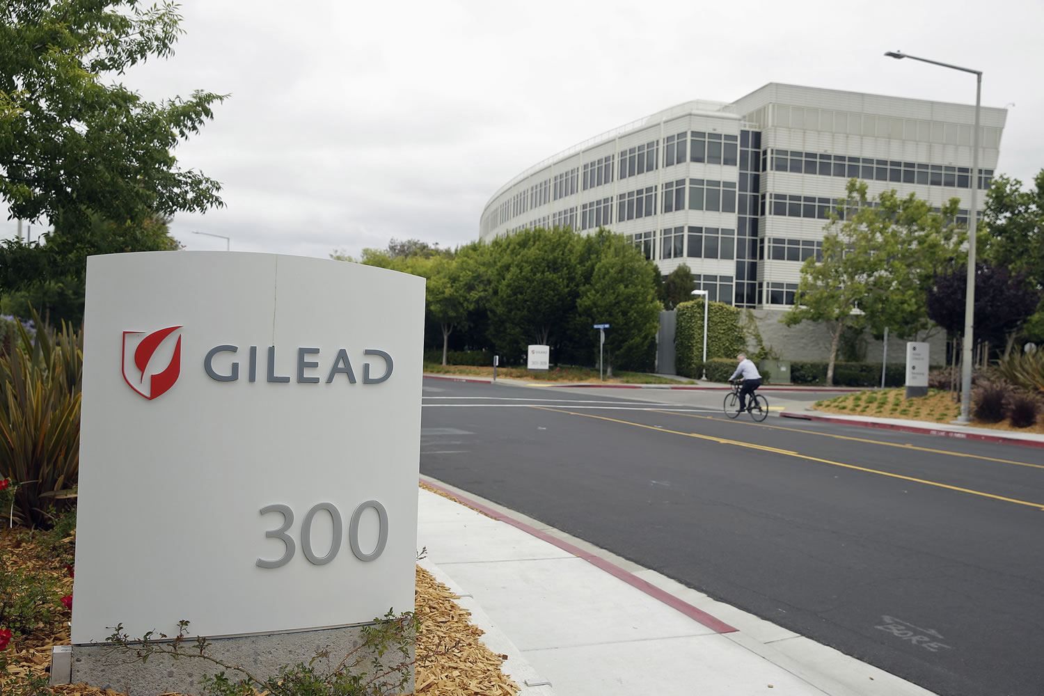 A man cycles near the headquarters of Gilead Sciences in Foster City, Calif.