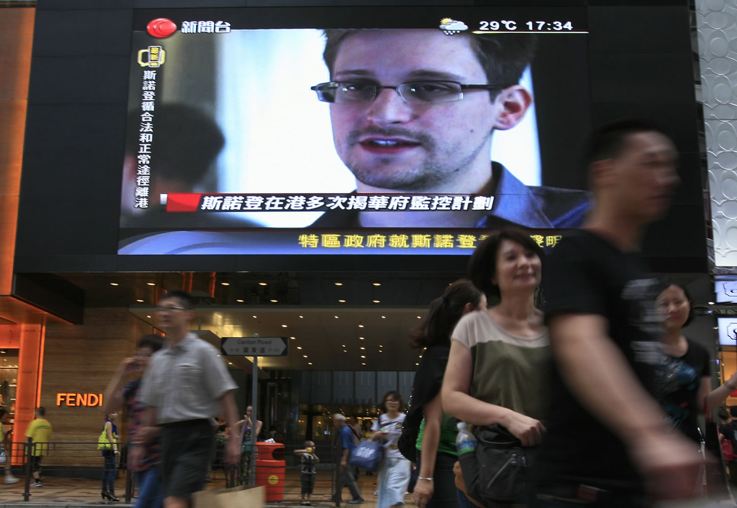 A TV screen shows a news report of Edward Snowden, a former CIA employee who leaked top-secret documents about sweeping U.S.