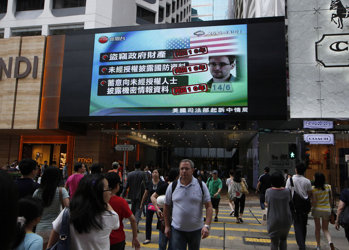 A TV screen shows a news report of Edward Snowden, a former CIA employee who leaked top-secret documents about sweeping U.S. surveillance programs, at a shopping mall in Hong Kong on Saturday.