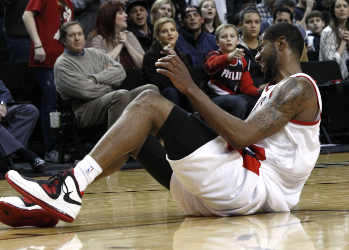 Don Ryan/The Associated Press
Blazers forward LaMarcus Aldridge grimaces after spraining his ankle on Sunday against the Hornets.
