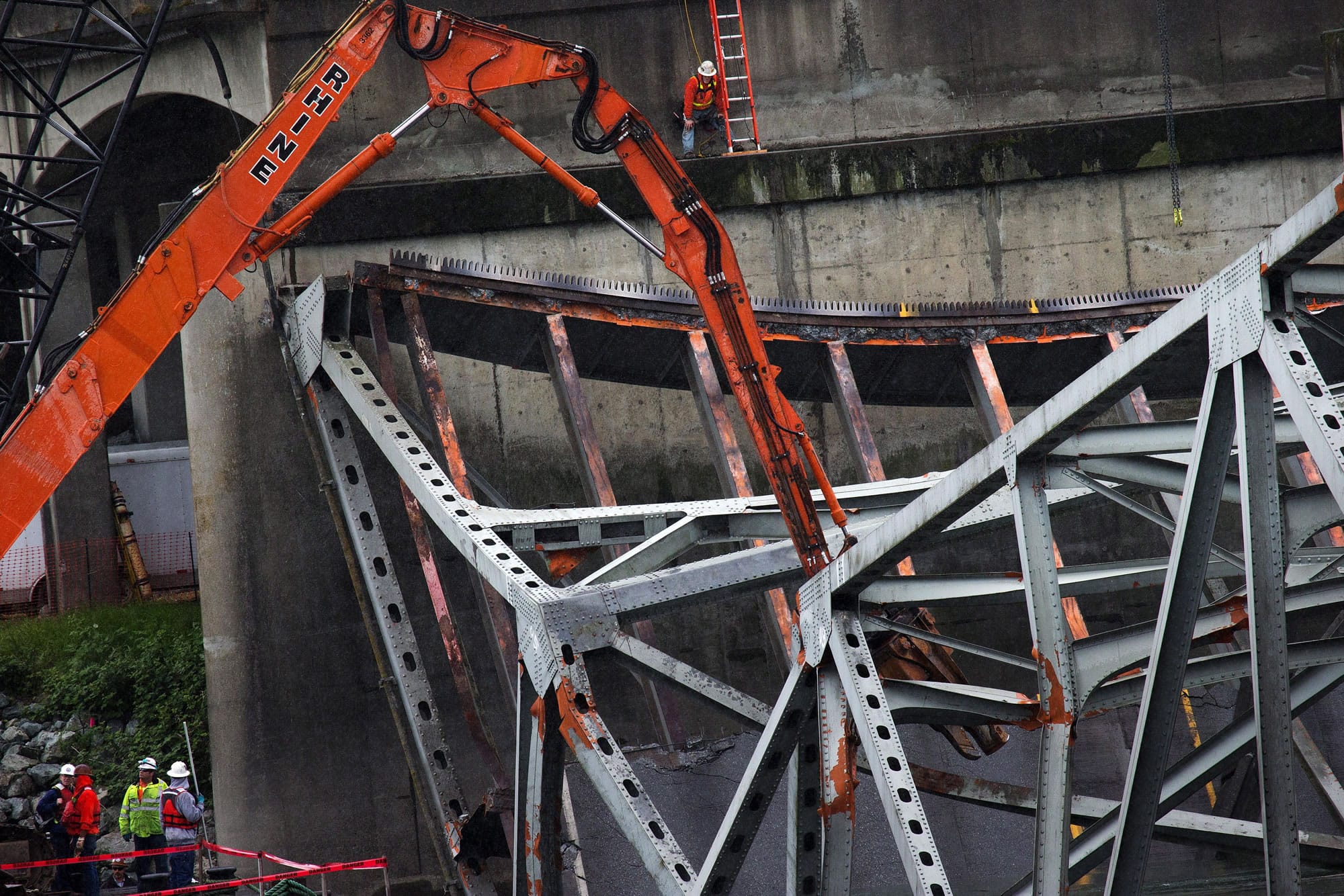 Barges transporting cranes and excavators begin the difficult work of removing debris and collecting evidence from the Skagit River at the site of the I-5 bridge collapse, in Mount Vernon.