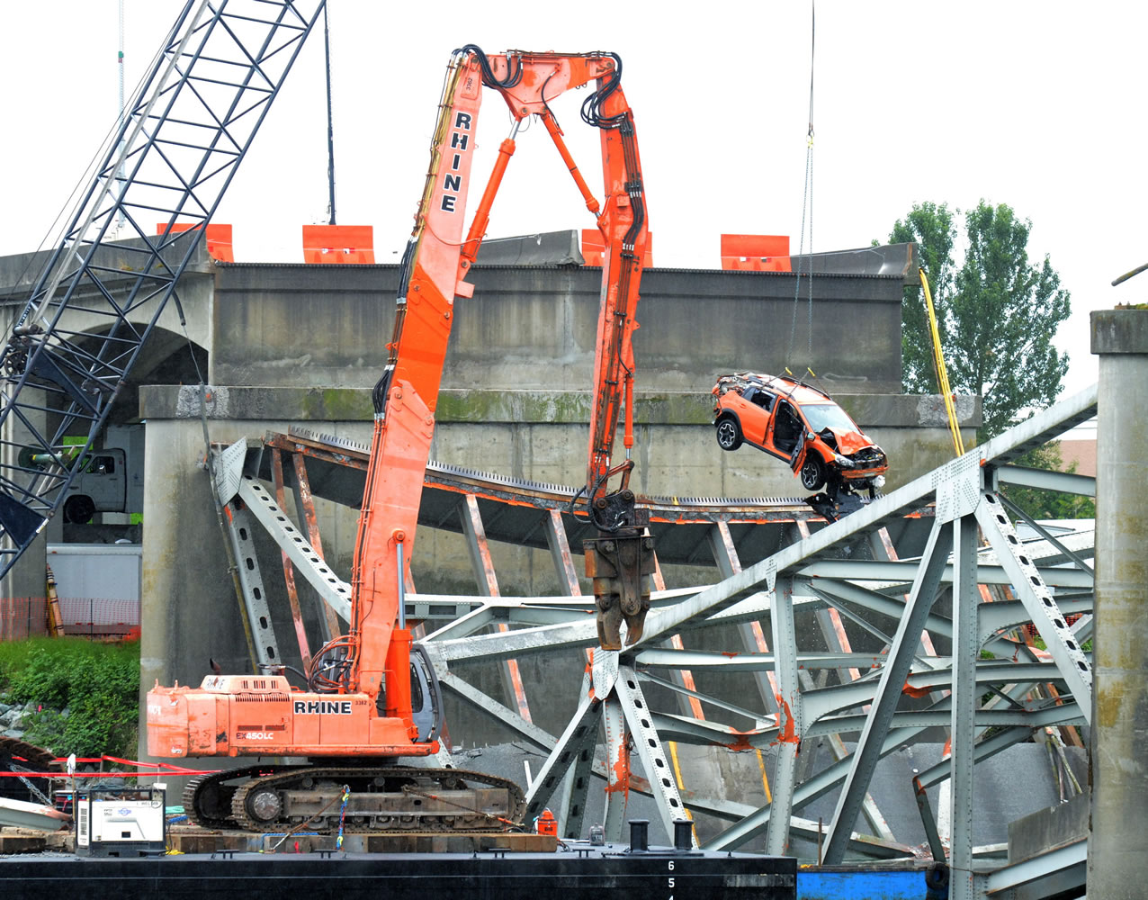Washington State DOT and contract workers remove the SUV and pickup truck from the deck of the collapsed Skagit River bridge on Monday in Mount Vernon.