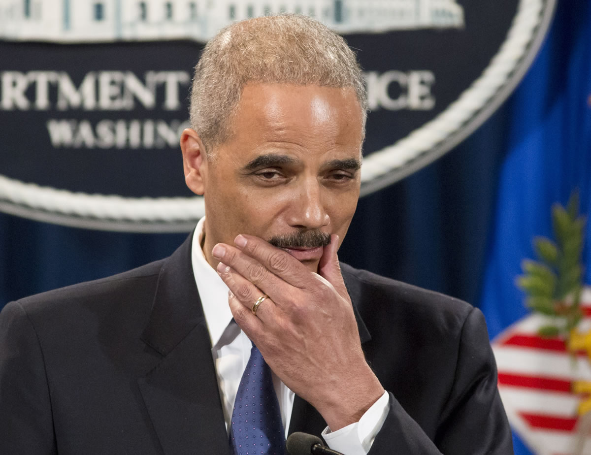 Attorney General Eric Holder pauses during a news conference at the Justice Department in Washington on Tuesday .