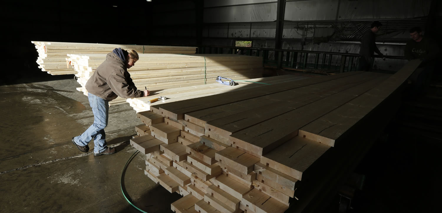 In this Friday, Dec. 21, 2012 photo, Erin Hall marks a load of wood trim at Belco Forest Products in Shelton, Wash. Hall was hired after an audit by the U.S. Immigration and Customs Enforcement Department resulted in the layoff of more than 20 workers for having suspect documents authorizing them to work in the United States. (AP Photo/Ted S.
