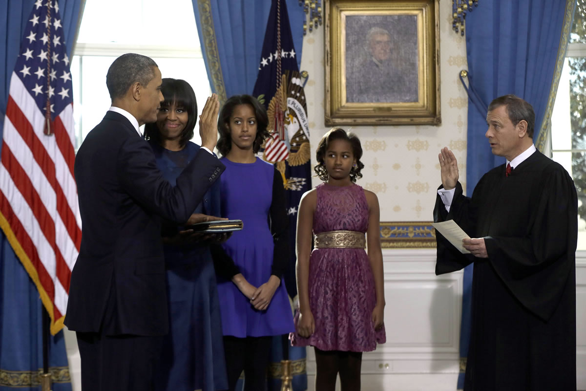 President Barack Obama, left, is officially sworn in Sunday by Chief Justice John Roberts, right, at the White House in Washington.