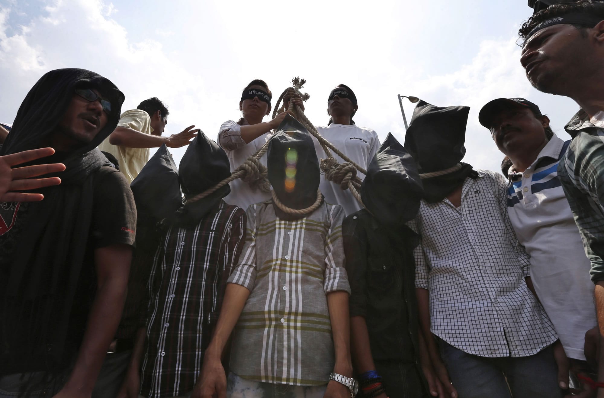Indian protesters stage a mock hanging scene to demand death sentence for four men after a judge convicted them in the fatal gang rape of a young woman on a moving New Delhi bus last year, in New Delhi, India, on Tuesday.