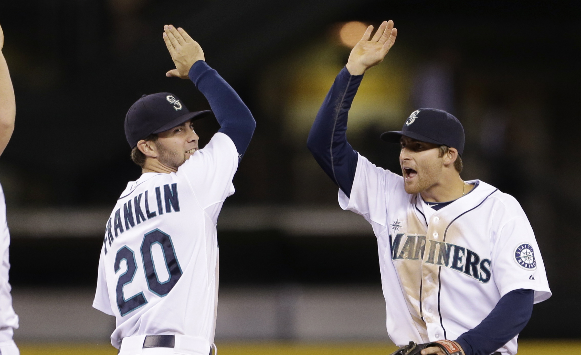 Seattle Mariners Nick Franklin (20) and Brad Miller share congratulations after the team beat the Cleveland Indians in  a baseball game Tuesday, July 23, 2013, in Seattle. The Mariners won 4-3.