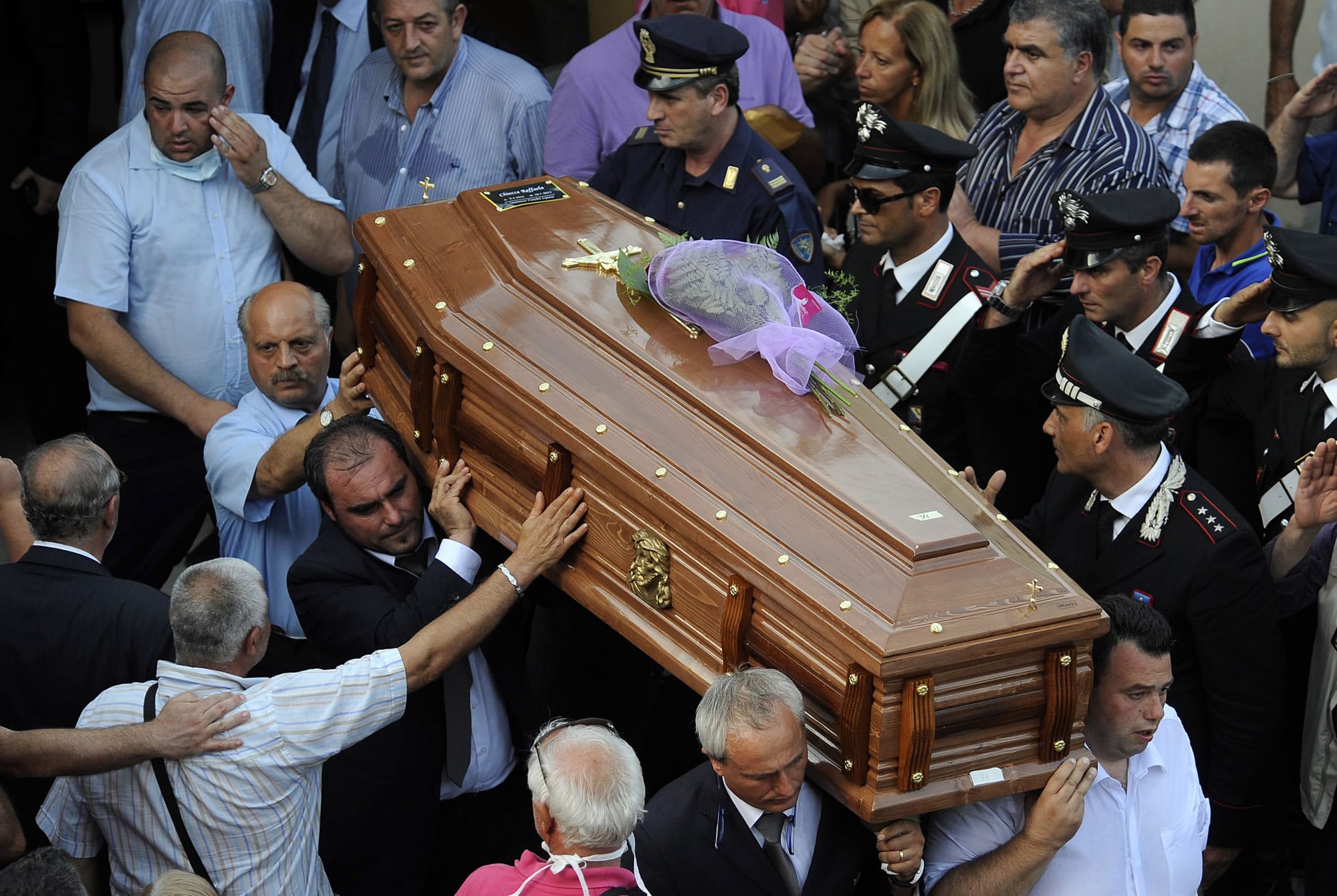 The coffin with one of the victims is carried away from a facility of an elementary school turned into a morgue in Monteforte Irpino, southern Italy, on Monday.