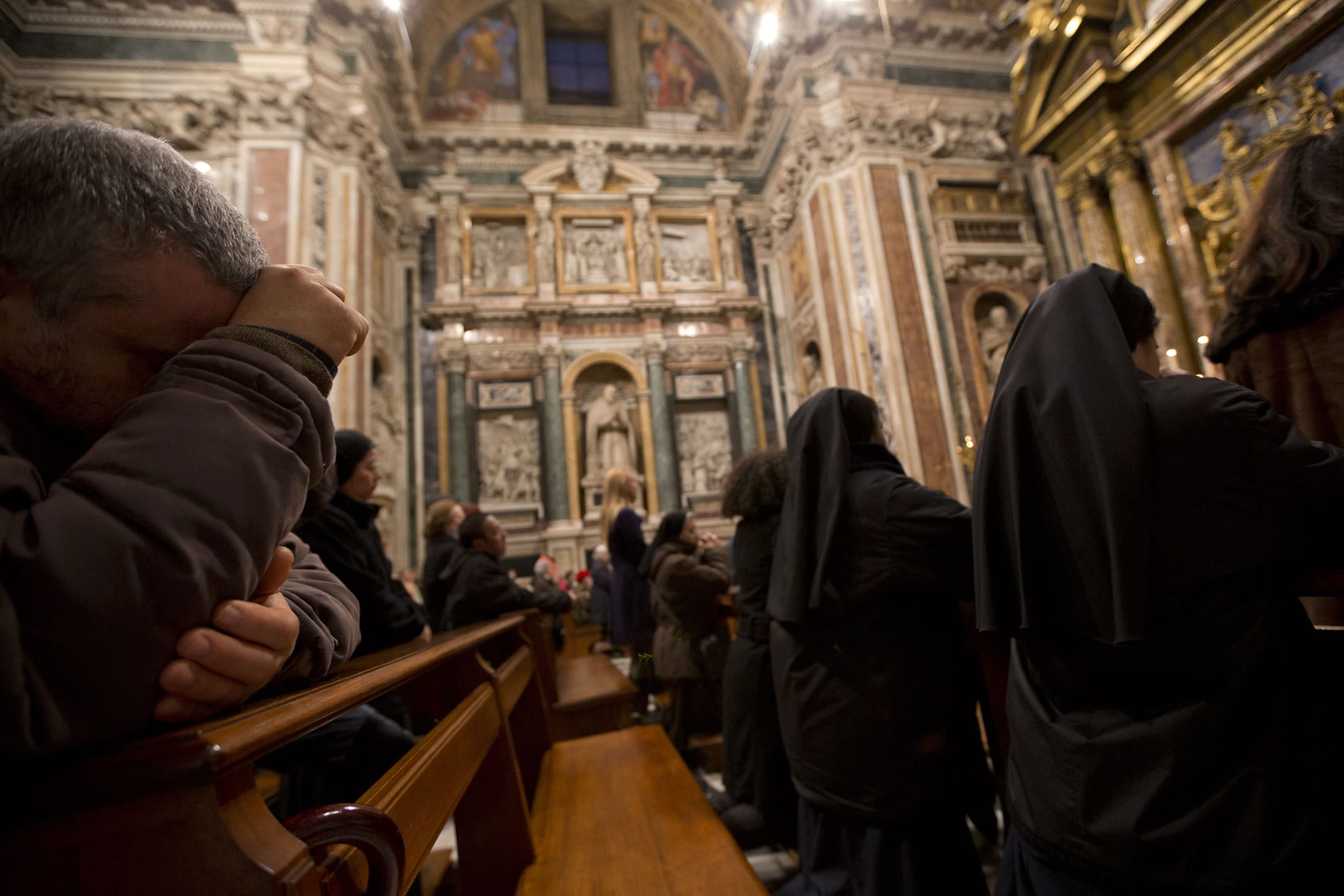 Faithful and nuns pray during a Mass for the election of the pope in Rome's Saint Mary Major Basilica on Thursday.