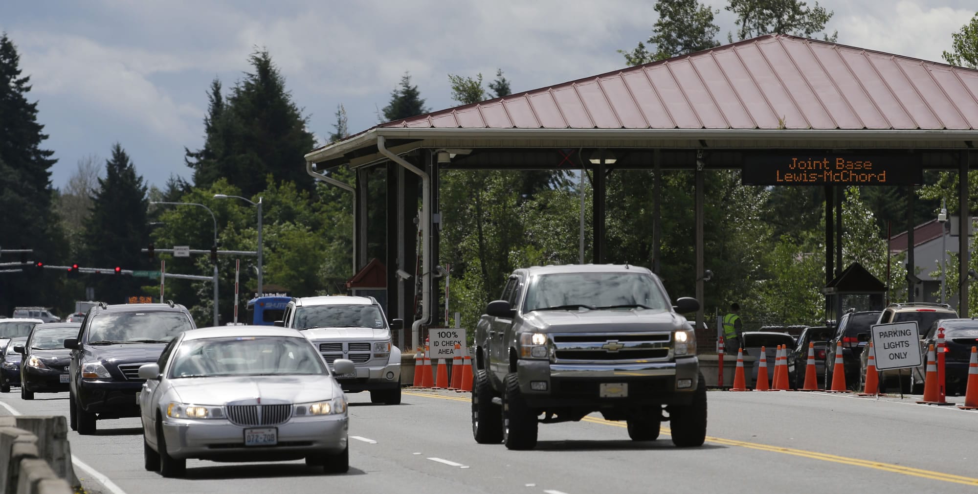 Cars drive in and out of Joint Base Lewis-McChord at the Madigan Gate on Tuesday,