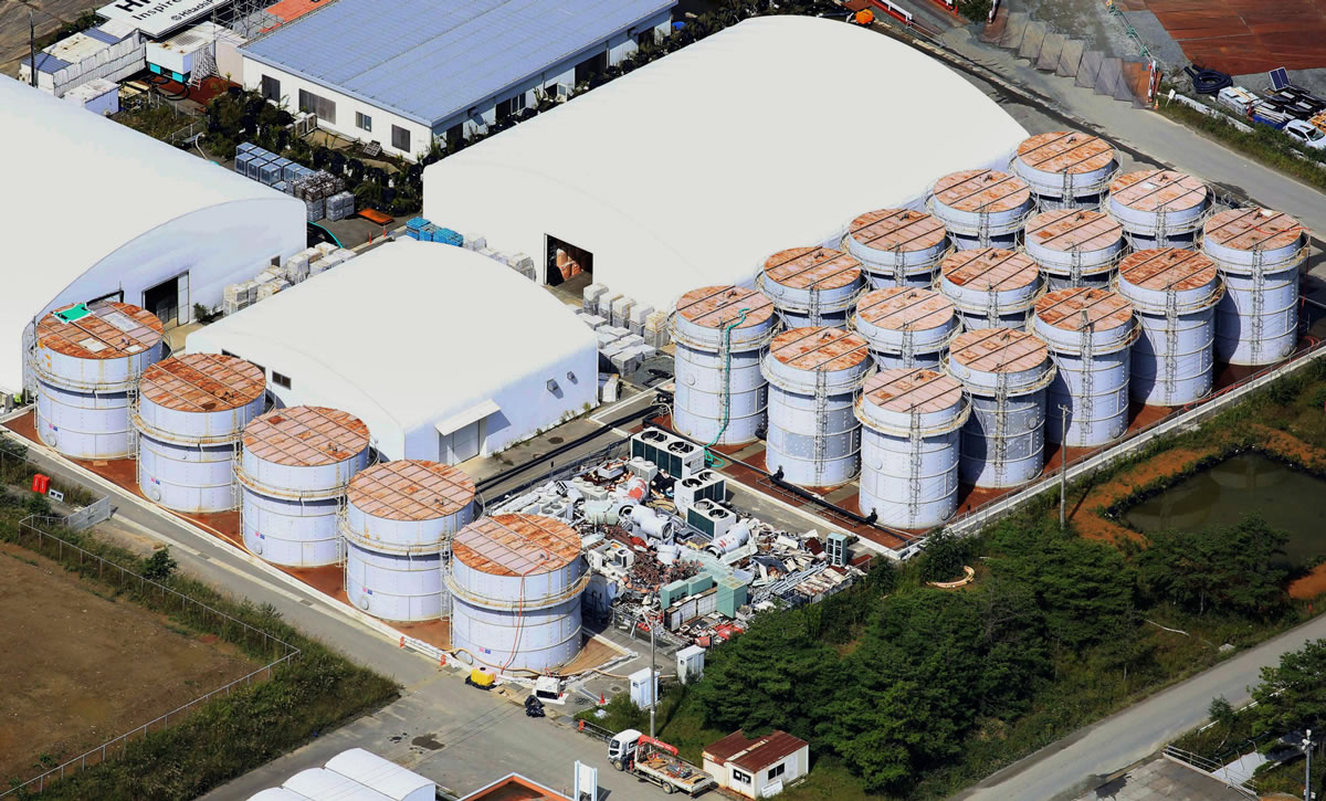 This aerial photo shows the storage tank, fifth from left at left plot, which workers detected the water dripping from the top, at the Fukushima Dai-ichi nuclear plant at Okuma town in Fukushima prefecture, northeastern Japan Thursday, Oct. 3, 2013.  Japan's crippled nuclear plant has a new leak of highly radioactive water entering the Pacific Ocean after a storage tank overflowed.