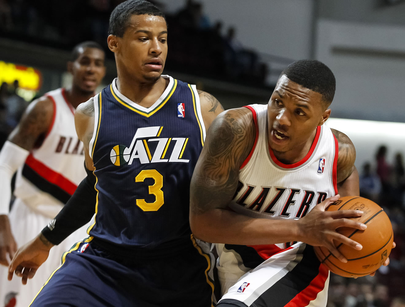 Portland Trail Blazers point guard Damian Lillard, right, drives the ball past Utah Jazz point guard Trey Burke (3) in the first half of a preseason game on Friday at Boise, Idaho.