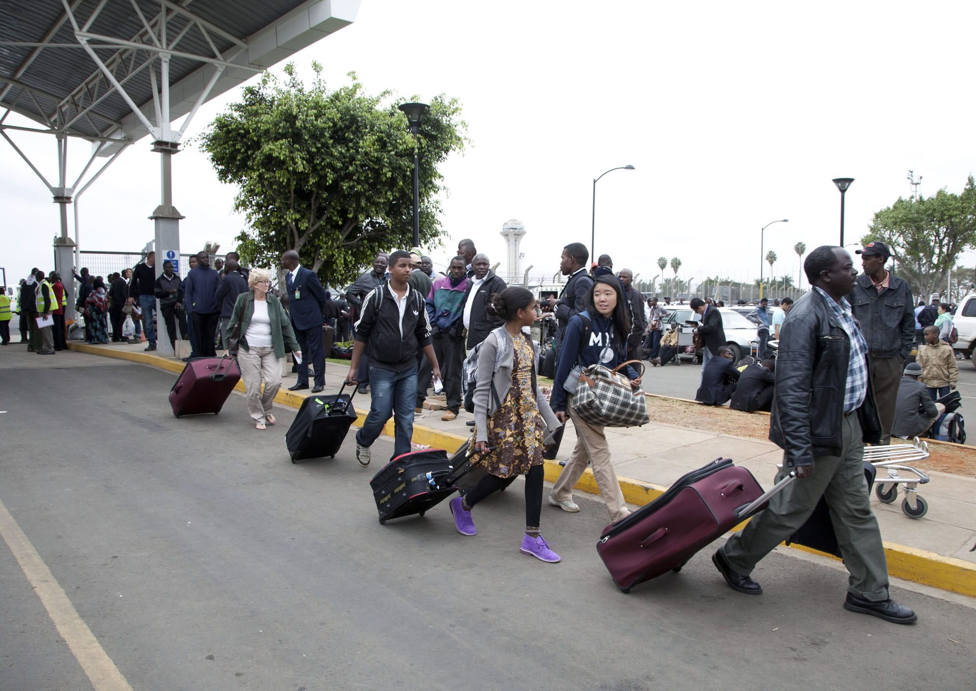 International passengers walk from the airport to be taken to the hotels, after the airport was closed and flights suspended after fire engulfed the International arrivals unit of Jomo Kenyatta International Airport, Nairobi, Kenya, on Wednesday.