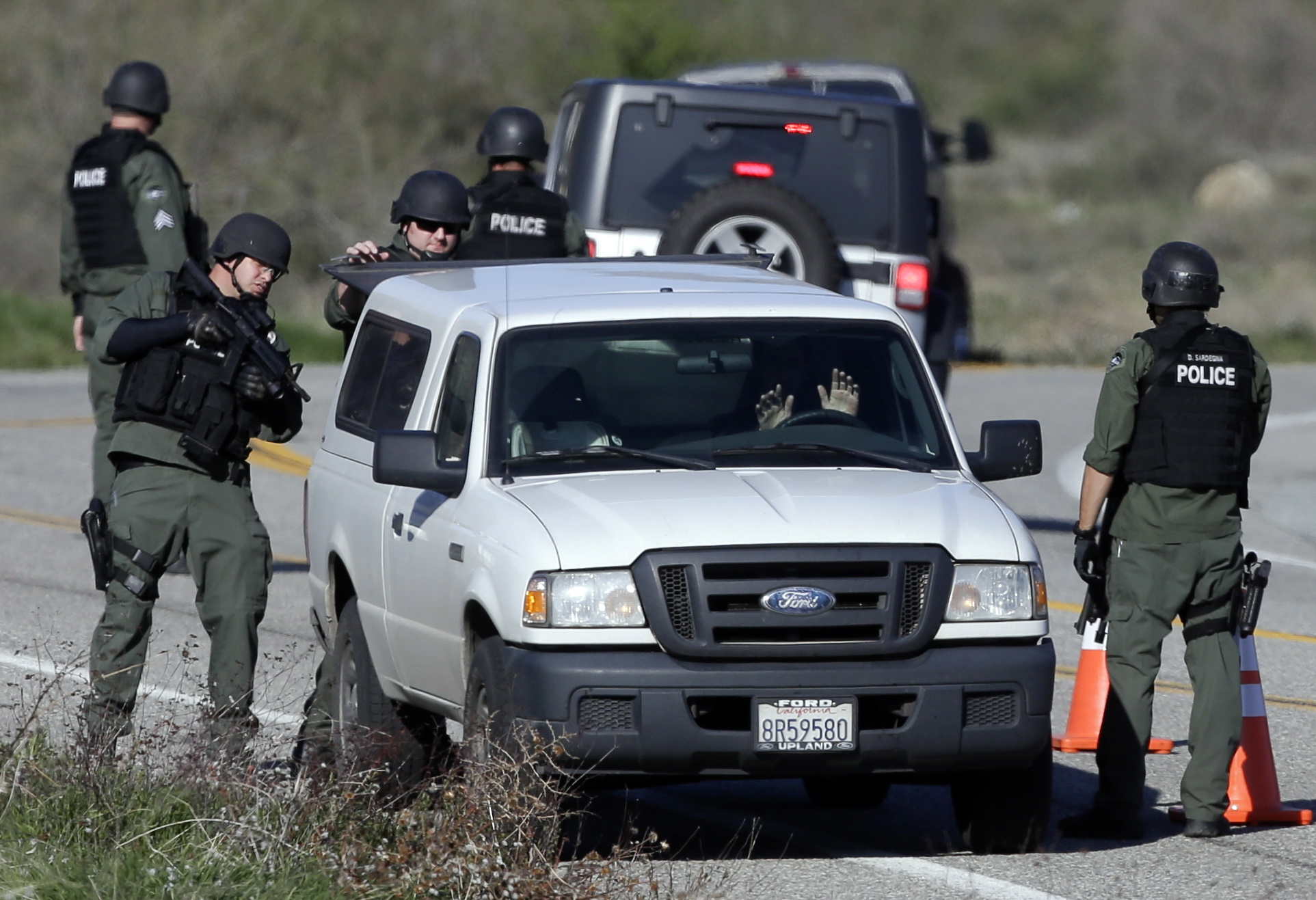 Law enforcement personnel search a vehicle along Hwy. 38 during the hunt for accused killer and ex-Los Angeles police officer Christopher Dorner in Yacaipa, Caif., on Tuesday.