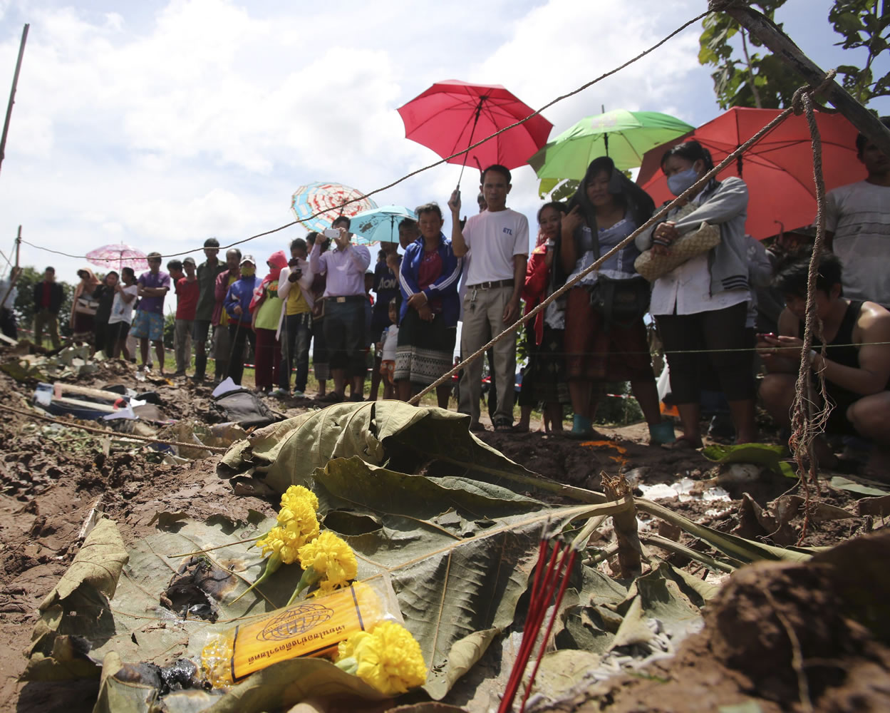 People look at the debris of a Lao Airlines turboprop plane, which crashed in Pakse, Laos, on Thursday.