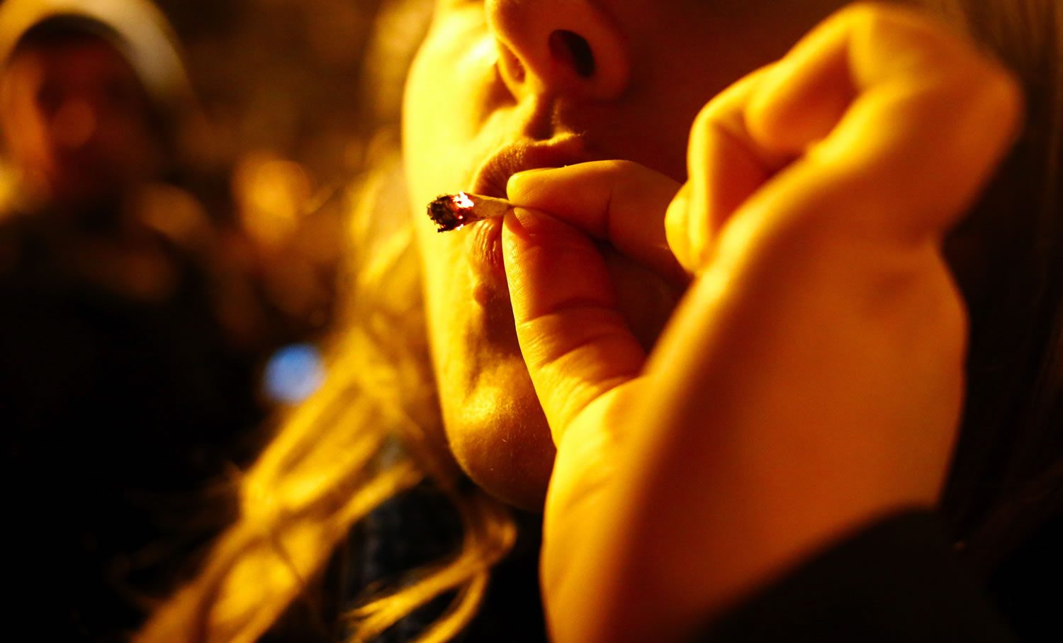 A 30-year-old woman smokes marijuana at a street party after I-502 was approved Tuesday in Seattle's Capitol Hill neighborhood. Initiative 502 decriminalizes the possession of up to an ounce of marijuana beginning Dec.
