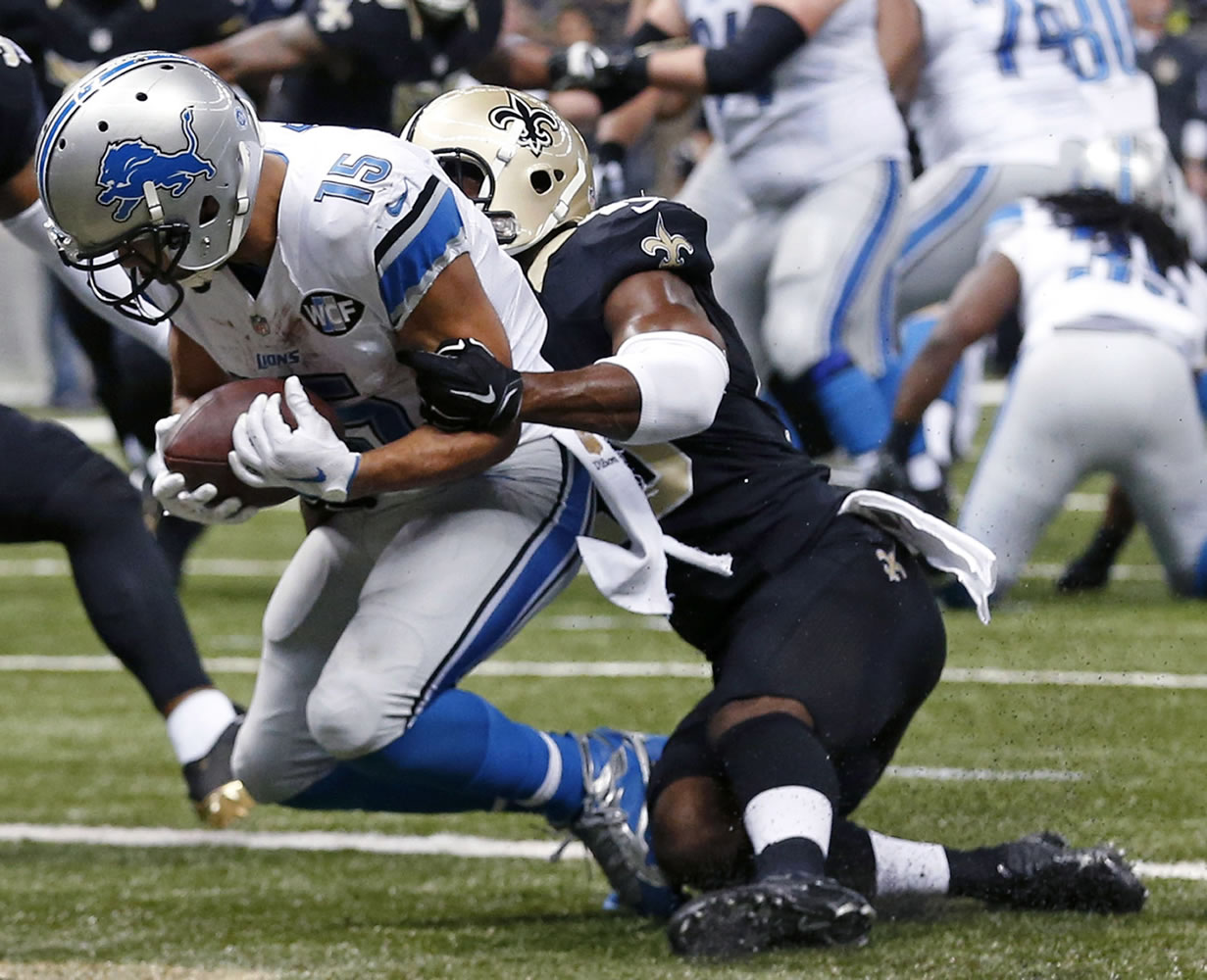 Detroit Lions wide receiver Golden Tate (15) pulls in a touchdown reception as New Orleans Saints cornerback Delvin Breaux tries to tackle in the first half of an NFL football game in New Orleans, Monday, Dec. 21, 2015.