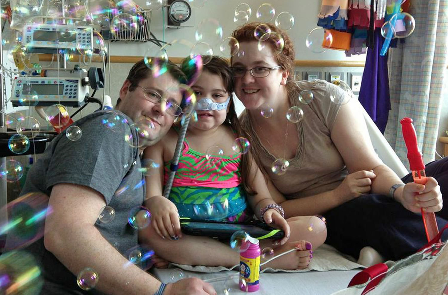Sarah Murnaghan, center, celebrates the 100th day of her stay in Children's Hospital of Philadelphia with her father, Fran, left, and mother, Janet.