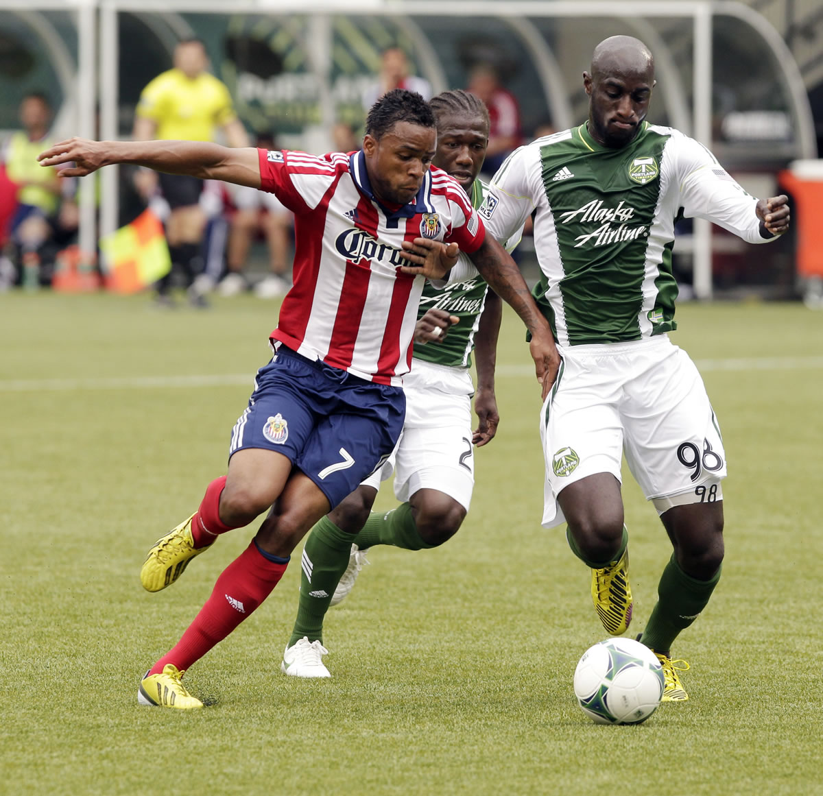 Chivas USA forward Tristan Bowen, Bowen, left, and Portland Timbers defender Mamadou Danso, right, chase down the ball as Timbers midfielder Diego Chara follows close behind during the first half Sunday.