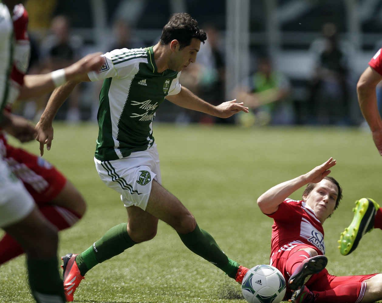 Portland Timbers midfielder Diego Valeri, left, is challenged by sliding FC Dallas defender Zach Loyd during the first half of the Timbers' 1-0 victory on June 9 at Jeld-Wen Field in Portland. The teams, who have split a pair of Major League Soccer matches this season, play today in Frisco, Texas, in the quarterfinals of the Lamar Hunt U.S.