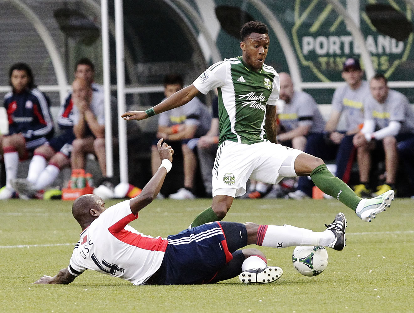 New England Revolution midfielder Kalifa Cisse, left, slides in to steal the ball from Portland Timbers forward Rodney Wallace during the first half Thursday.