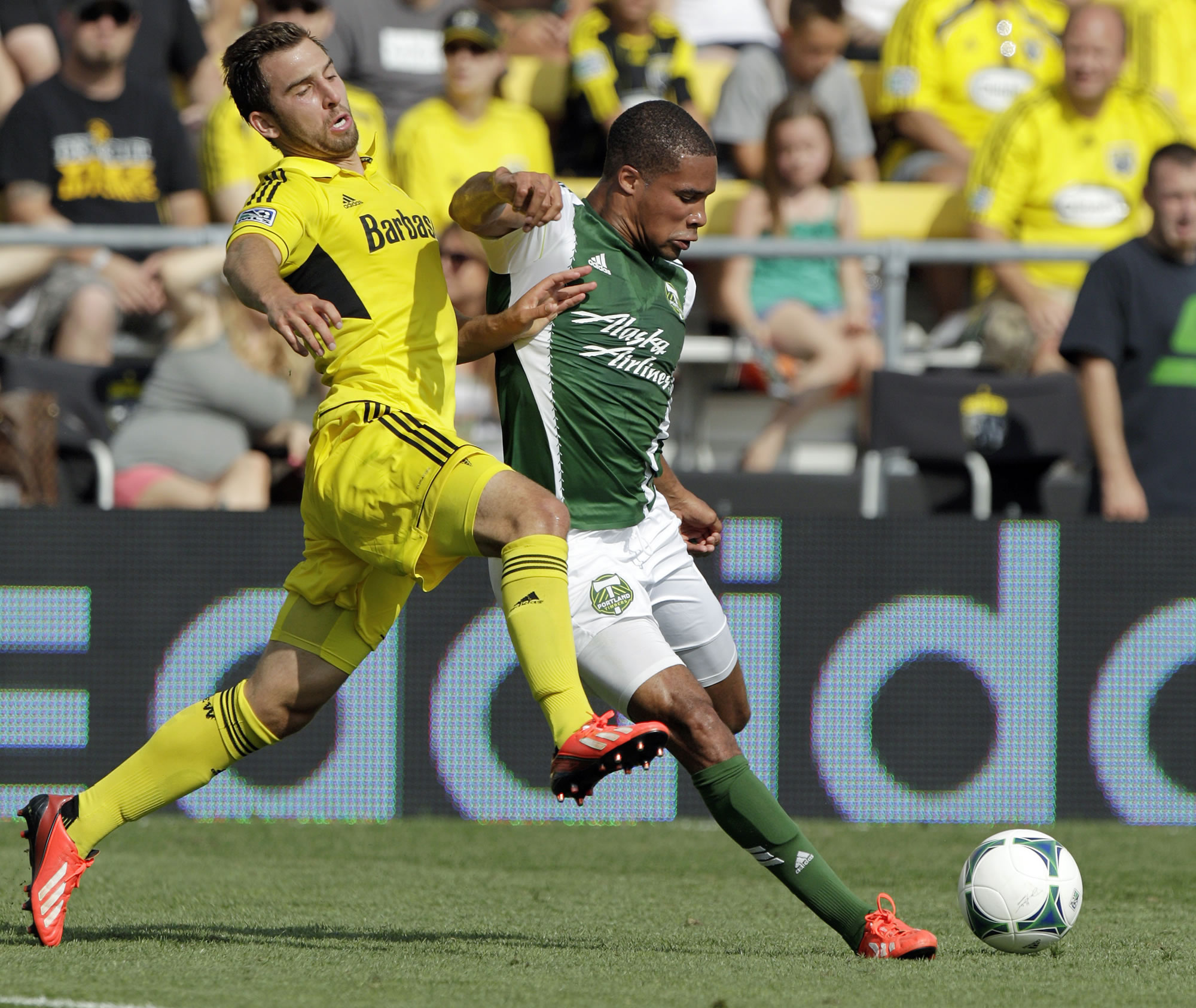 Portland Timbers' Ryan Johnson, right, tries to kick the ball past Columbus Crew's Chad Barson during the first half Sunday at Columbus, Ohio.