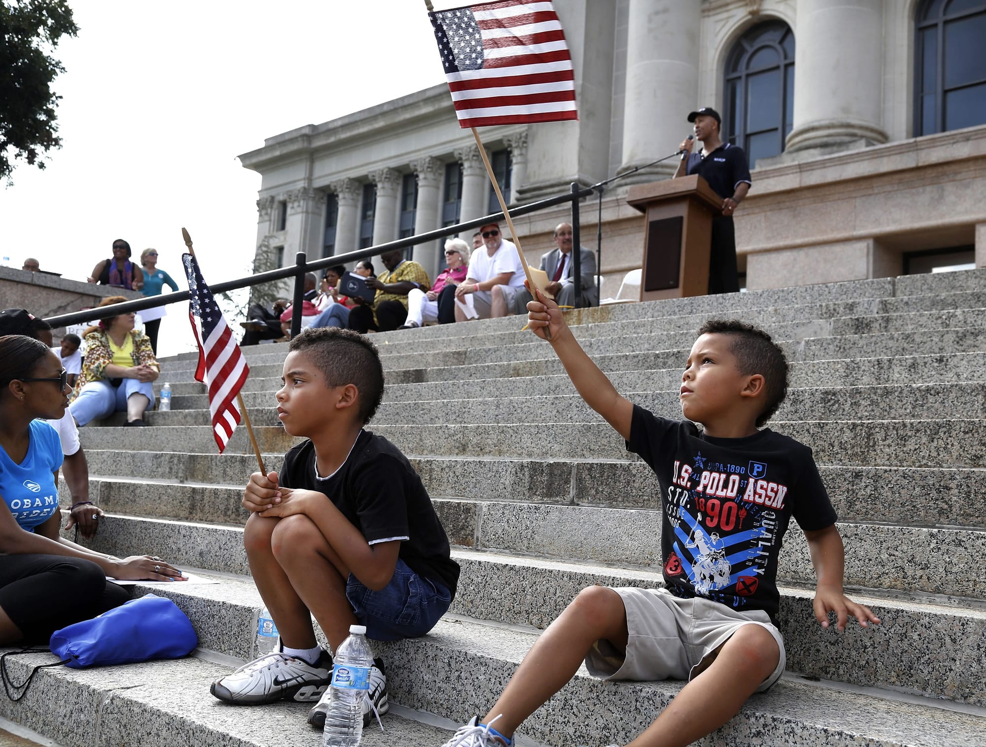 Dejuan Monroe, 7, waves an American flag in the air while a speaker addresses the crowd. Dejuan and his older brother Darian, 9, moved to the front of the crowd and found a good view of the rally on the north steps of the Capitol.