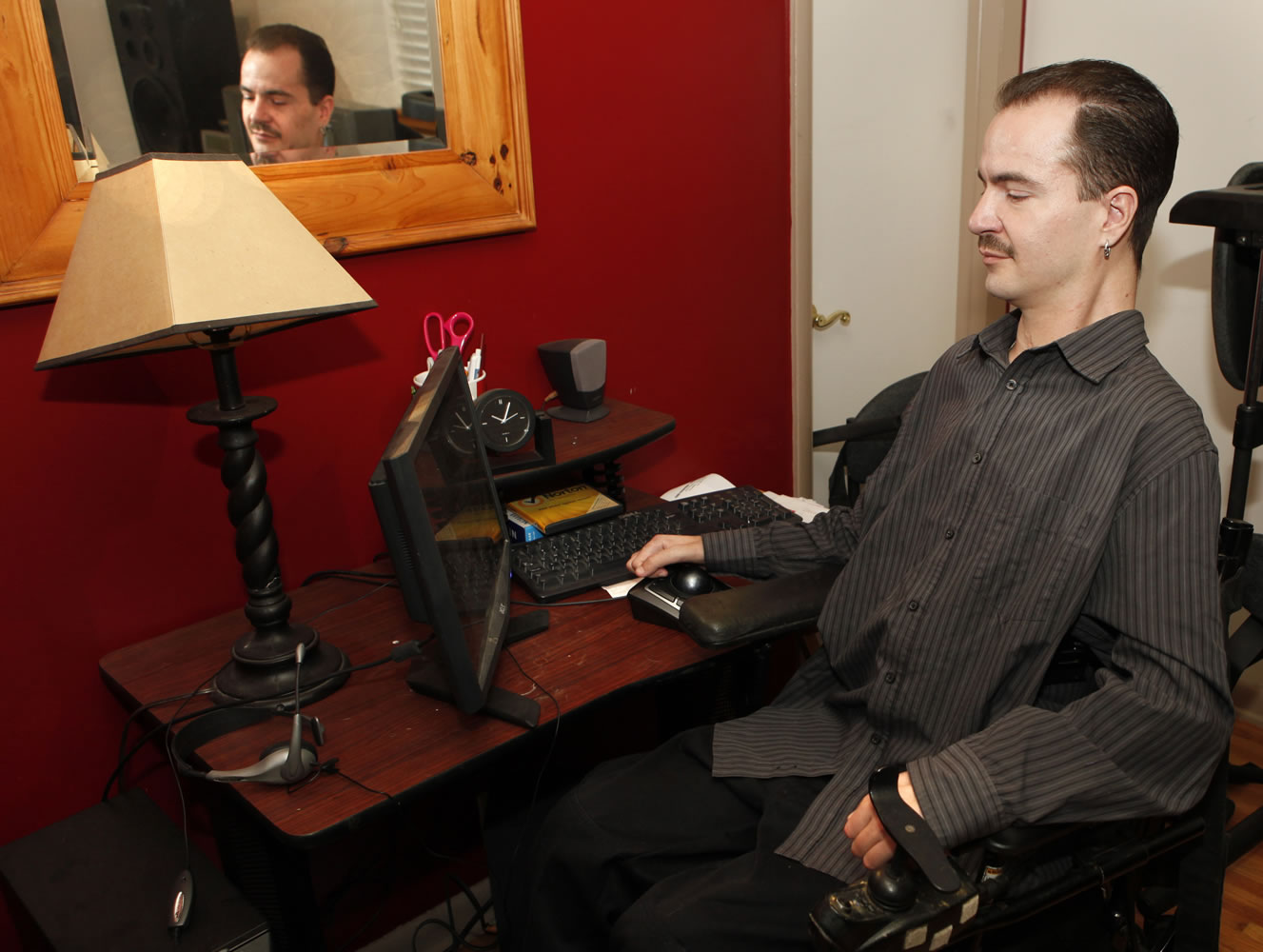 Brandon Coats works on his computer at his home in Denver on Thursday. Coats' Colorado case is giving employers pause. Coats, 33, was a telephone operator for Dish Network. Paralyzed as a teenager in a car crash, he's also been a medical marijuana patient in Colorado since 2009.