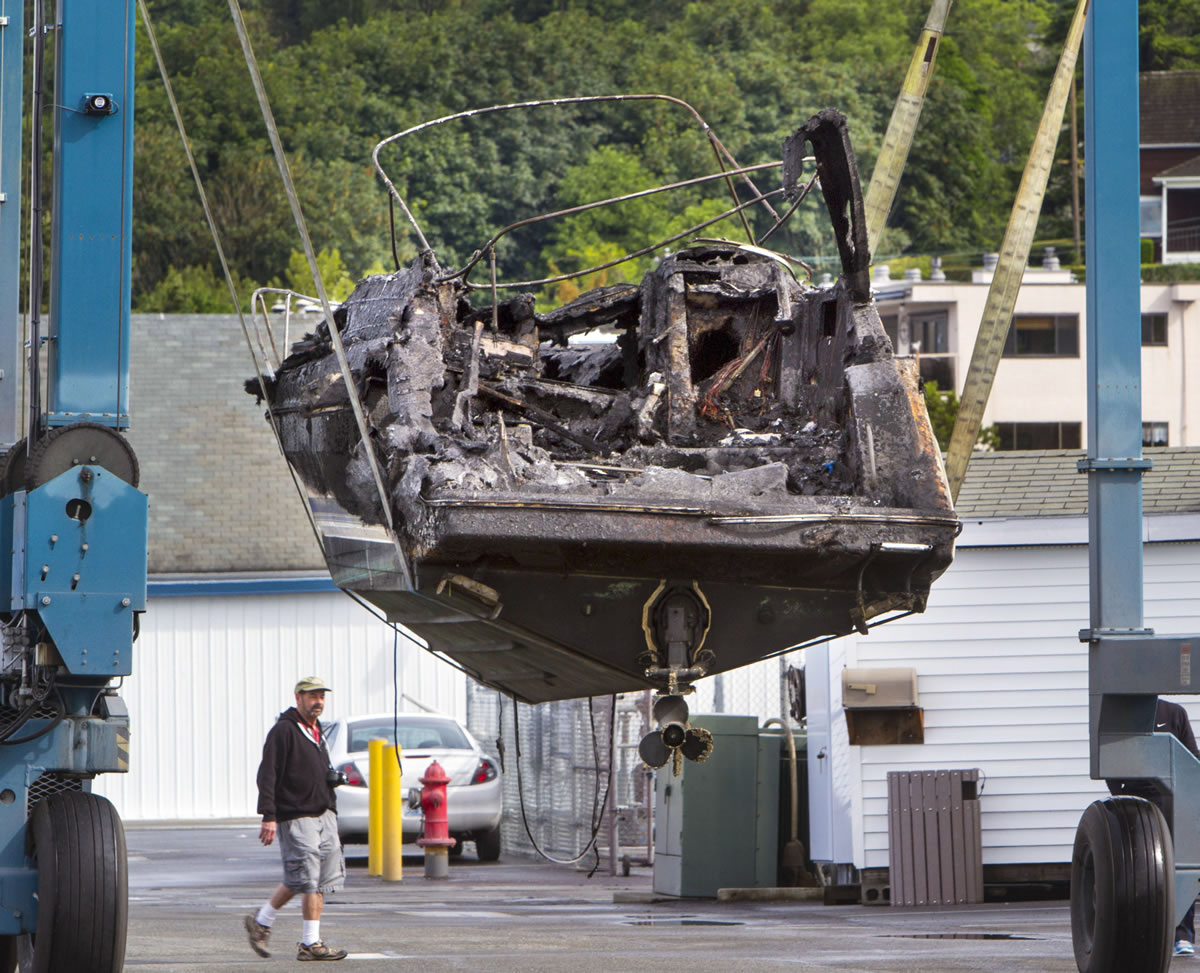 A destroyed boat is taken out of the water Monday at the Des Moines Marina on Puget Sound.