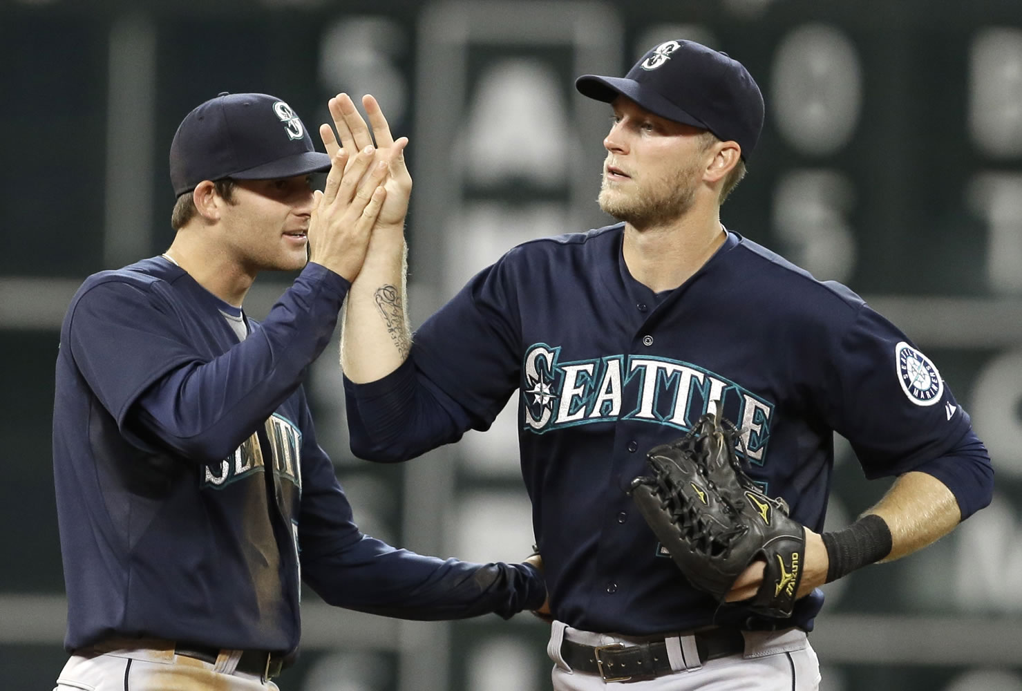Seattle Mariners' Brad Miller, left, and Michael Saunders celebrate the Mariners' 4-2 win over the Houston Astros on Saturday in Houston.