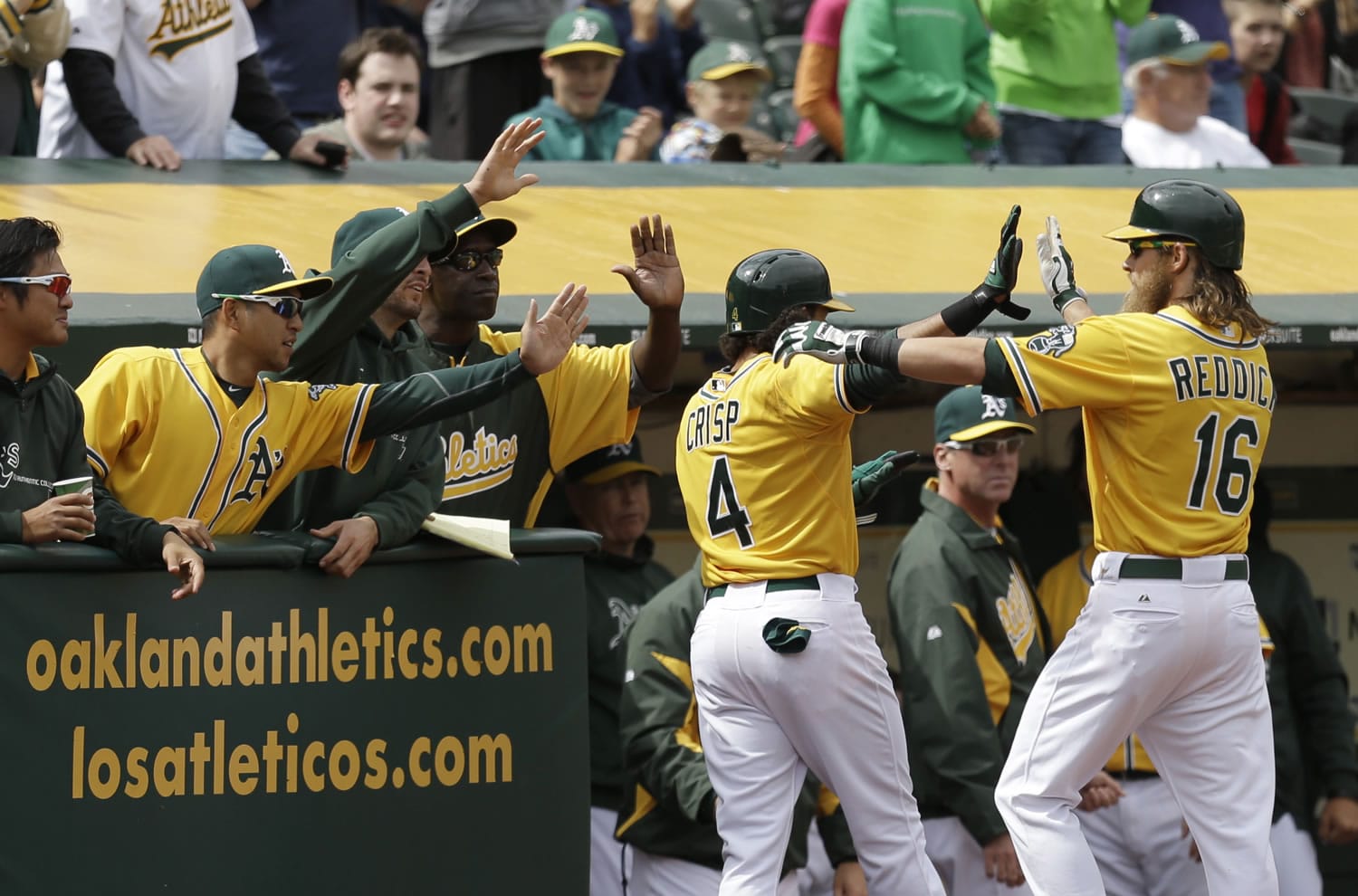 Oakland Athletics' Josh Reddick (16) and Coco Crisp (4) celebrate after Crisp scored against the Seattle Mariners in the eighth inning Thursday.