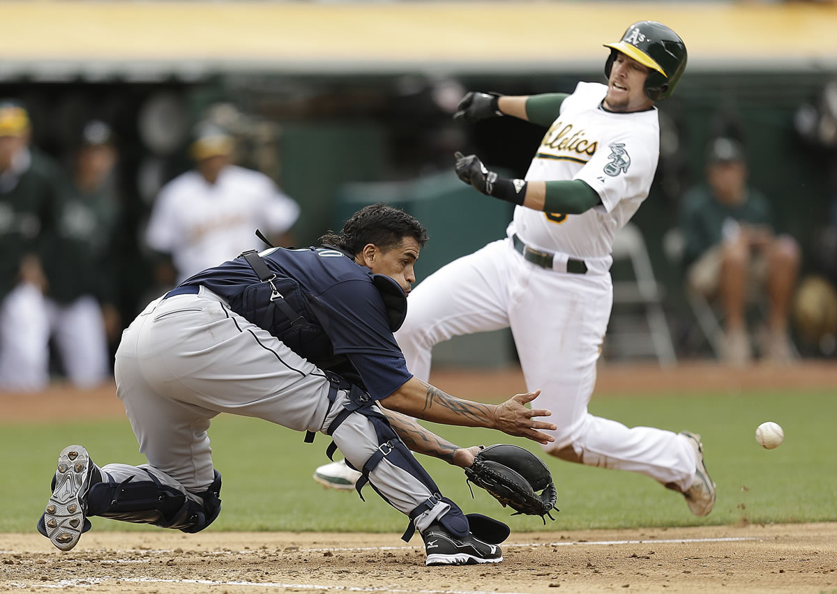 Seattle Mariners catcher Henry Blanco waits for the ball as Oakland Athletics' Jed Lowrie prepares to slide in the fifth inning Saturday.