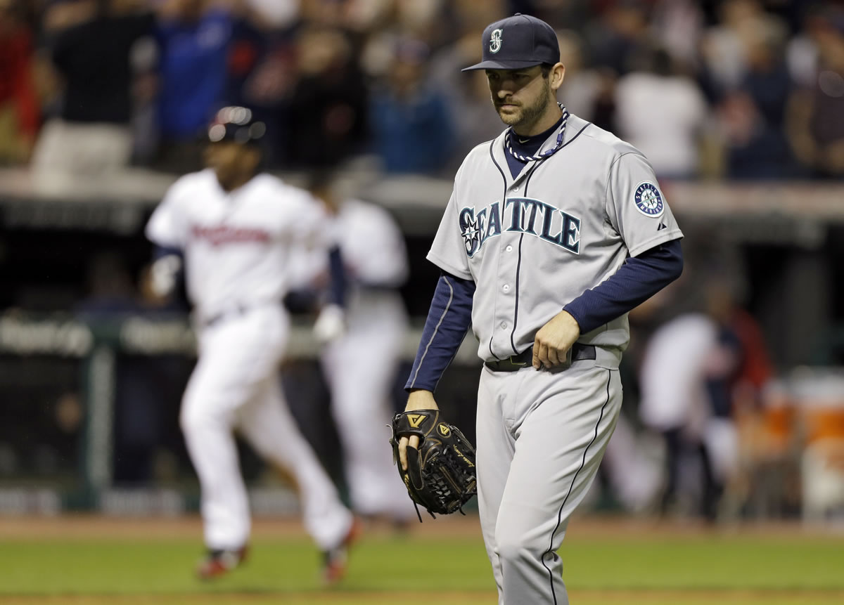 Seattle Mariners relief pitcher Lucas Luetge, foreground, walks off the field after giving up a game-winning, three-run home run to Cleveland Indians' Jason Kipnis in the 10th inning Friday.