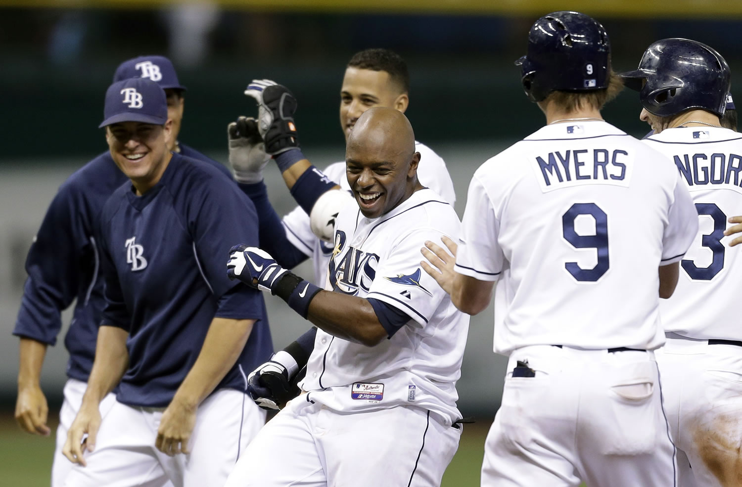 Tampa Bay Rays' Jason Bourgeois, center, celebrates with teammates after his ninth inning walk off hit off Seattle Mariners relief pitcher Danny Farquhar during a baseball game Wednesday, Aug. 14, 2013, in St. Petersburg, Fla. Rays' Matt Joyce scored on the hit.  The Rays won the game 5-4.