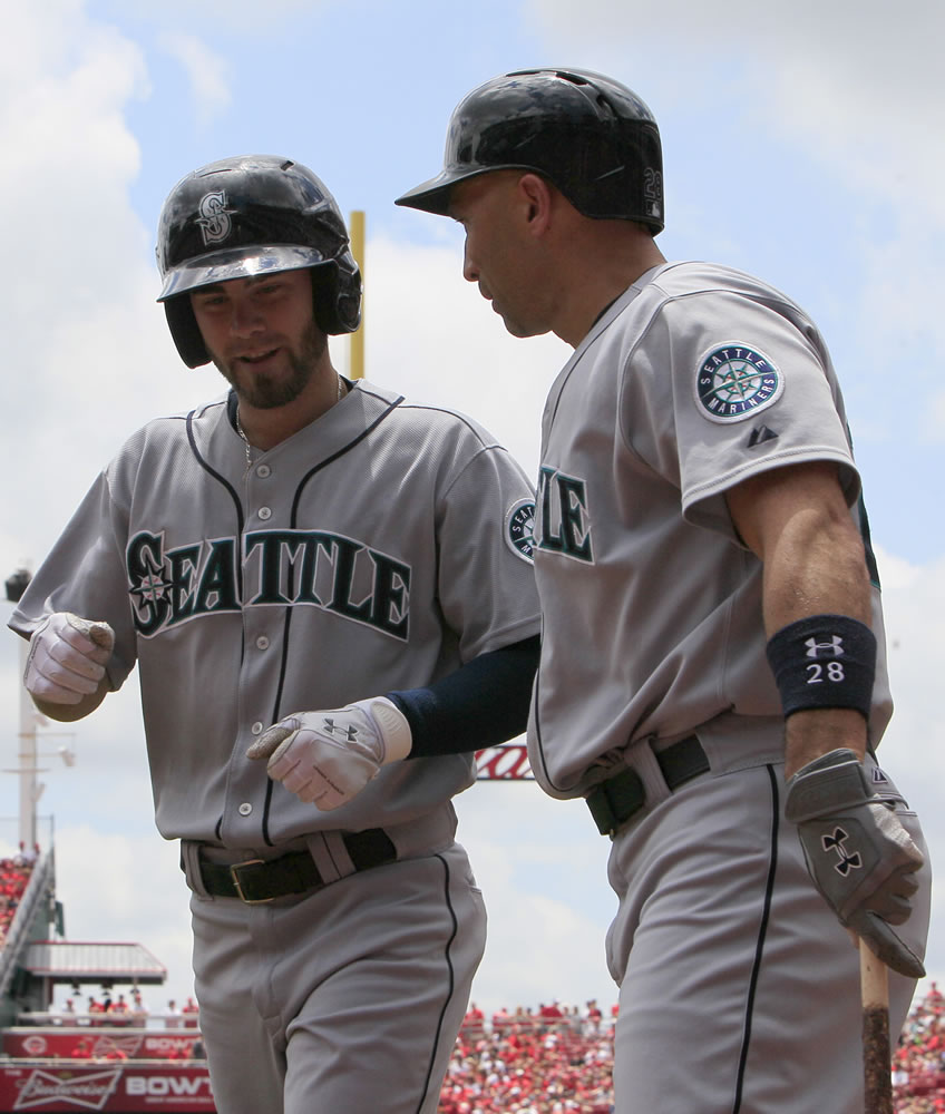 Seattle Mariners' Nick Franklin, left, is congratulated by teammate Raul Ibanez after hitting a solo home run off Cincinnati Reds starting pitcher Bronson Arroyo in the first inning during Sunday.
