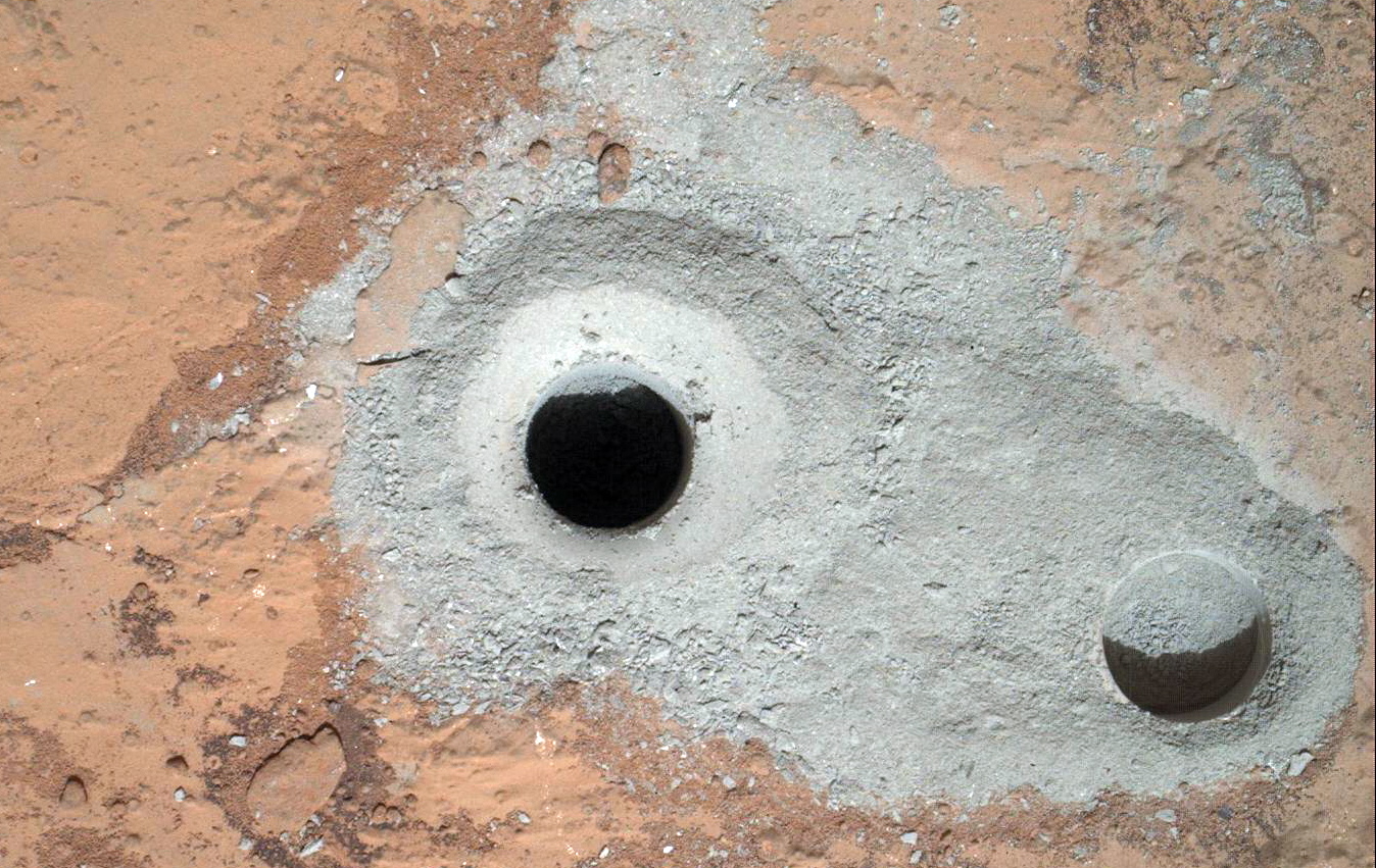NASA
This image released by NASA on Saturday shows a fresh drill hole, center, made by the Curiosity rover on Friday next to an earlier test hole. Curiosity has completed its first drill into a Martian rock, a huge milestone since landing in an ancient crater in August.