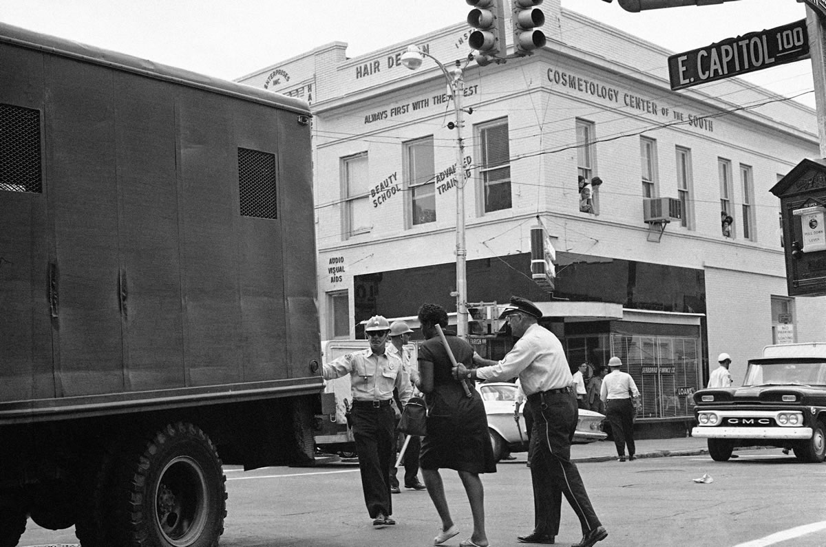 Police lead a woman into waiting truck after they broke up a racial demonstration in Jackson, Miss., on June 15, 1963.