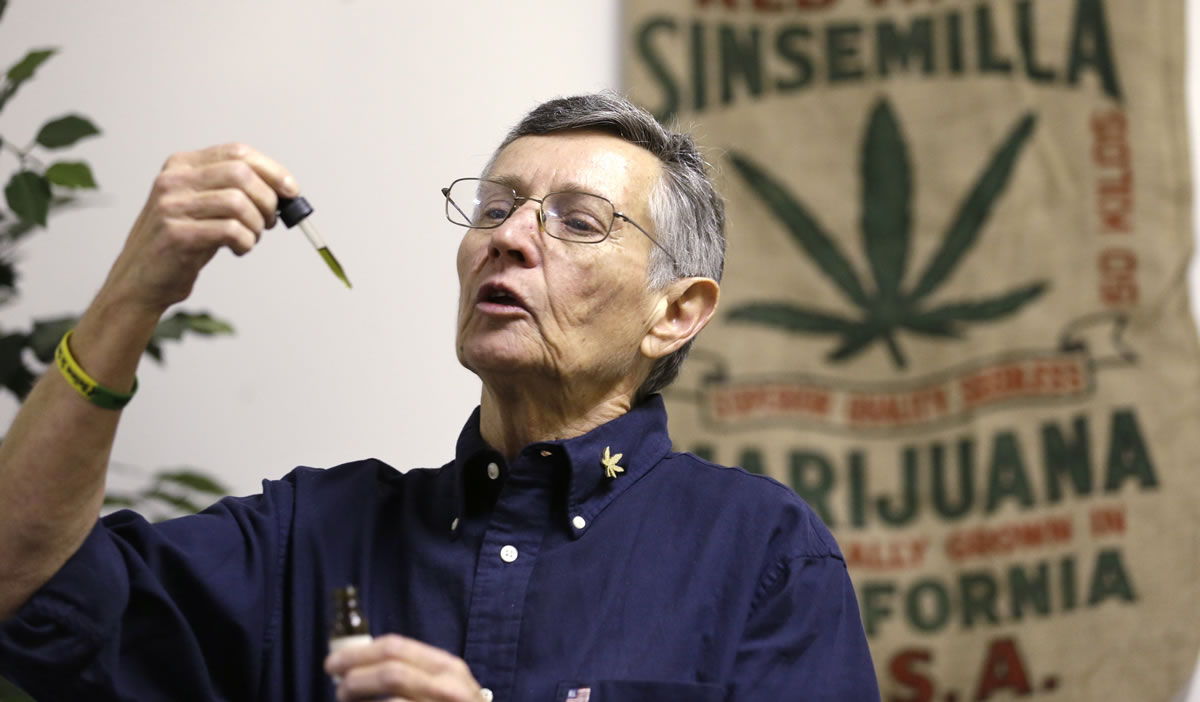 Medical marijuana dispensary proprietor Dawn Darington demonstrates to clients how to use a marijuana product tincture in Seattle.