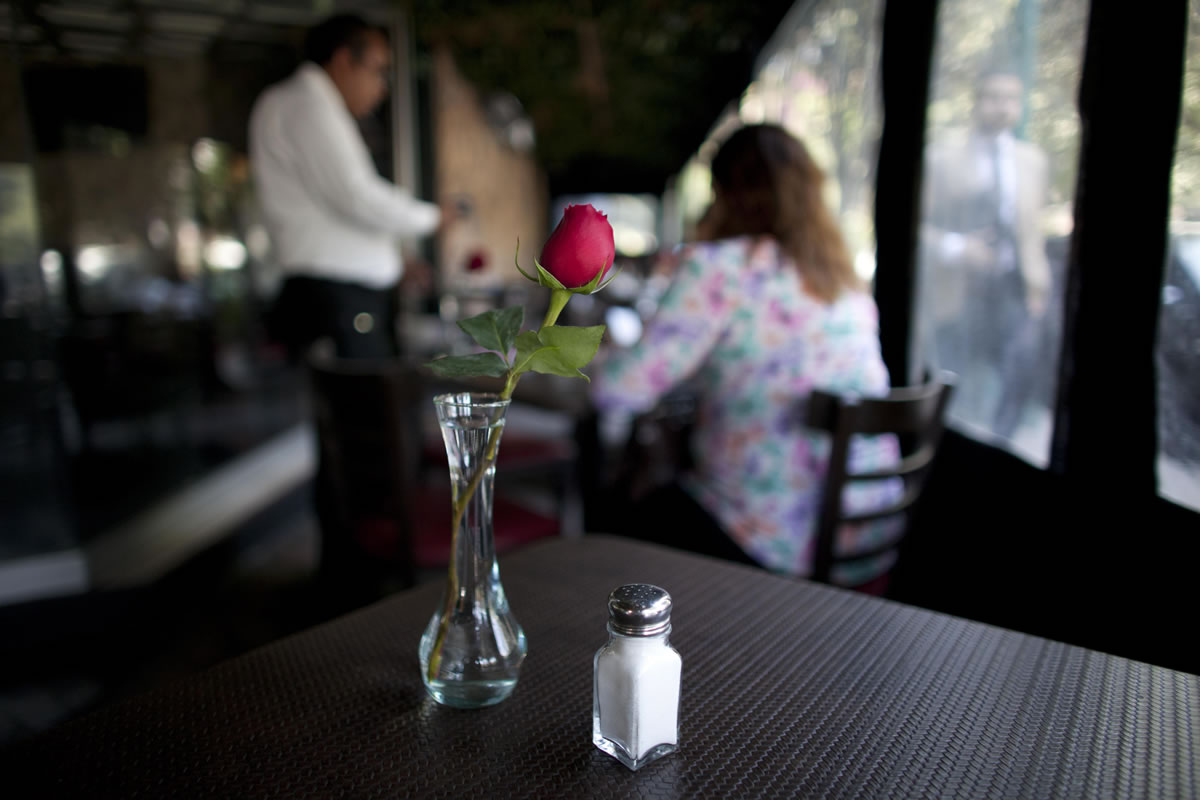 A salt shaker sits on a table in a restaurant in Mexico City.