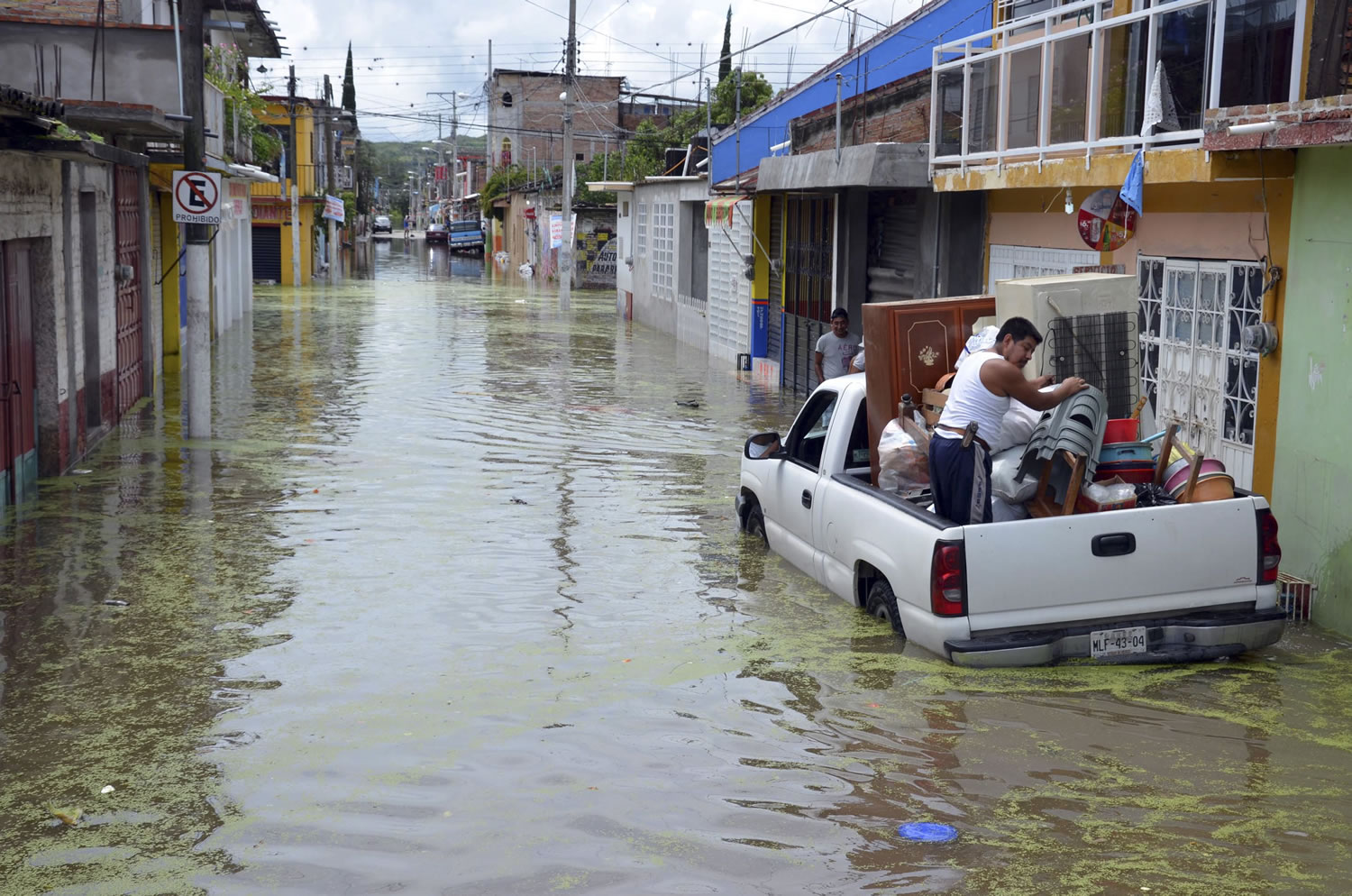 Villagers load belongings into a pickup truck Sunday in a flooded street in Tixtla de Guerrero, Mexico. Tropical Storm Manuel and Ingrid affected 24 of Mexico's 31 states and 371 municipalities, which are the equivalent of counties. More than 58,000 people were evacuated, with 43,000 taken to shelters.