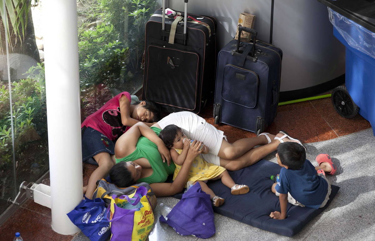 A family rests in a shelter as they wait to be ferried out by air, south of Acapulco, in Punta Diamante, Mexico, Wednesday, Sept. 18, 2013. Mexico was hit by the one-two punch of twin storms over the weekend, and the storm that soaked Acapulco on Sunday - Manuel -re-formed into a tropical storm Wednesday, threatening to bring more flooding to the country's northern coast. With roads blocked by landslides, rockslides, floods and collapsed bridges, Acapulco was cut off from road transport.