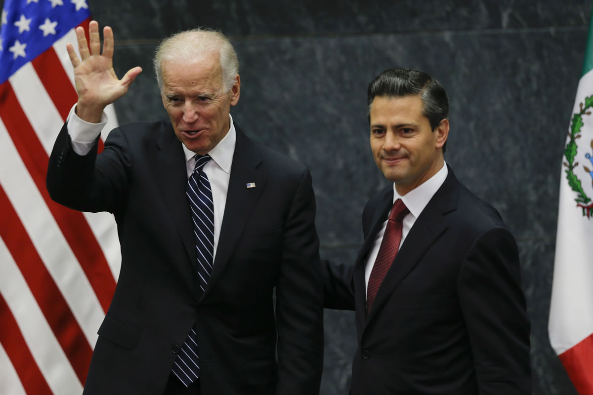 Vice President Joe Biden, left, waves as he's accompanied by Mexico's President Enrique Pena Nieto after delivering a message to the press at the Los Pinos presidential residence in Mexico City on  Friday.