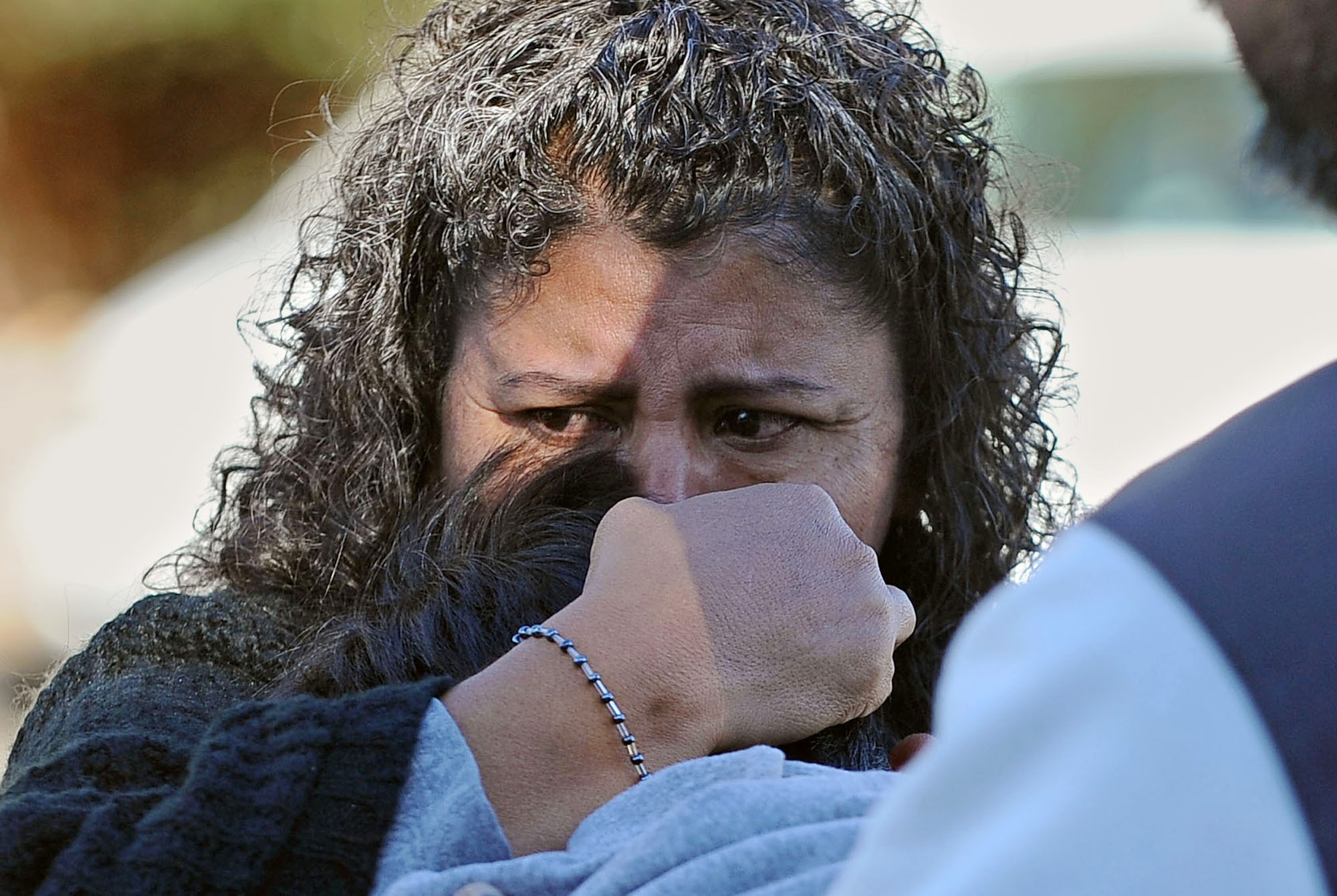 A unidentified woman holds her son after picking him up at Sparks high school were some students where taken after a shooting that left two dead at Sparks Middle School on Monday.