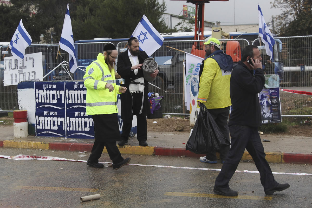 Israeli emergency service members stand at the scene of an alleged stabbing attack at Gush Etzion junction in the West Bank on Tuesday. A Palestinian attempted to stab a pedestrian at a busy junction outside of Jerusalem when Israeli troops shot and killed him, the military said.