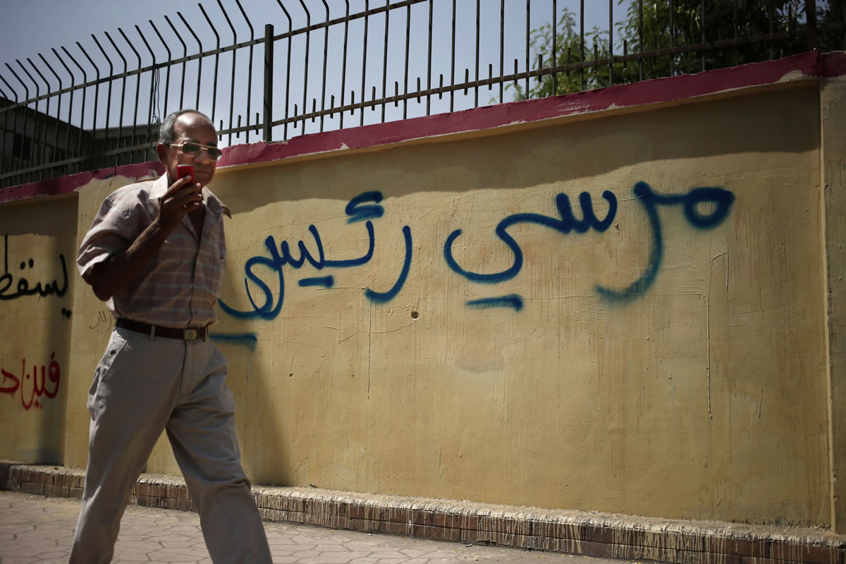 An Egyptian man walks by a graffiti in Arabic that reads, &quot;Morsi my president,&quot; referring to the ousted Egyptian President Mohammed Morsi, in Cairo, Egypt, on Sunday.